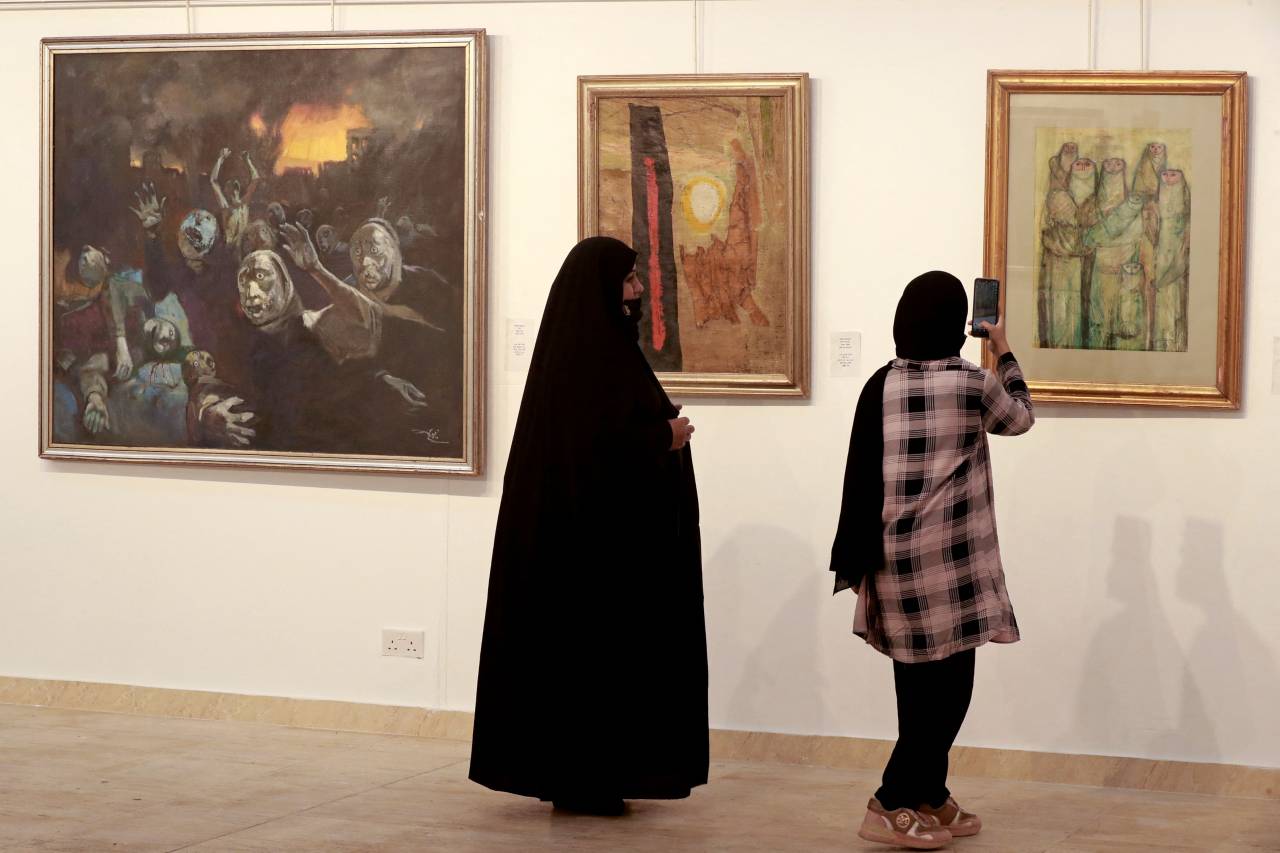 Des visiteuses observent les œuvres de Faeq Hassan exposées au ministère de la Culture irakien à Bagdad, le 6 avril 2022. Photo AHMAD AL-RUBAYE / AFP