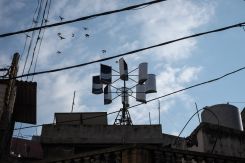 Muhammad al-Sabsabi’s homemade wind turbine of barrels and welded iron beams, on his grandmother’s roof in Bebnine, Akkar governorate. He’s titled his project “GreenNX.” Feb. 14, 2023. (Credit: João Sousa/L’Orient Today)
