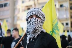 Un manifestant portant un drapeau de Hezbollah lors d'un rassemblement Hezbollah-Amal en solidarité avec Gaza dans la banlieue sud de Beyrouth, le 20 octobre 2023. Photo : João Sousa