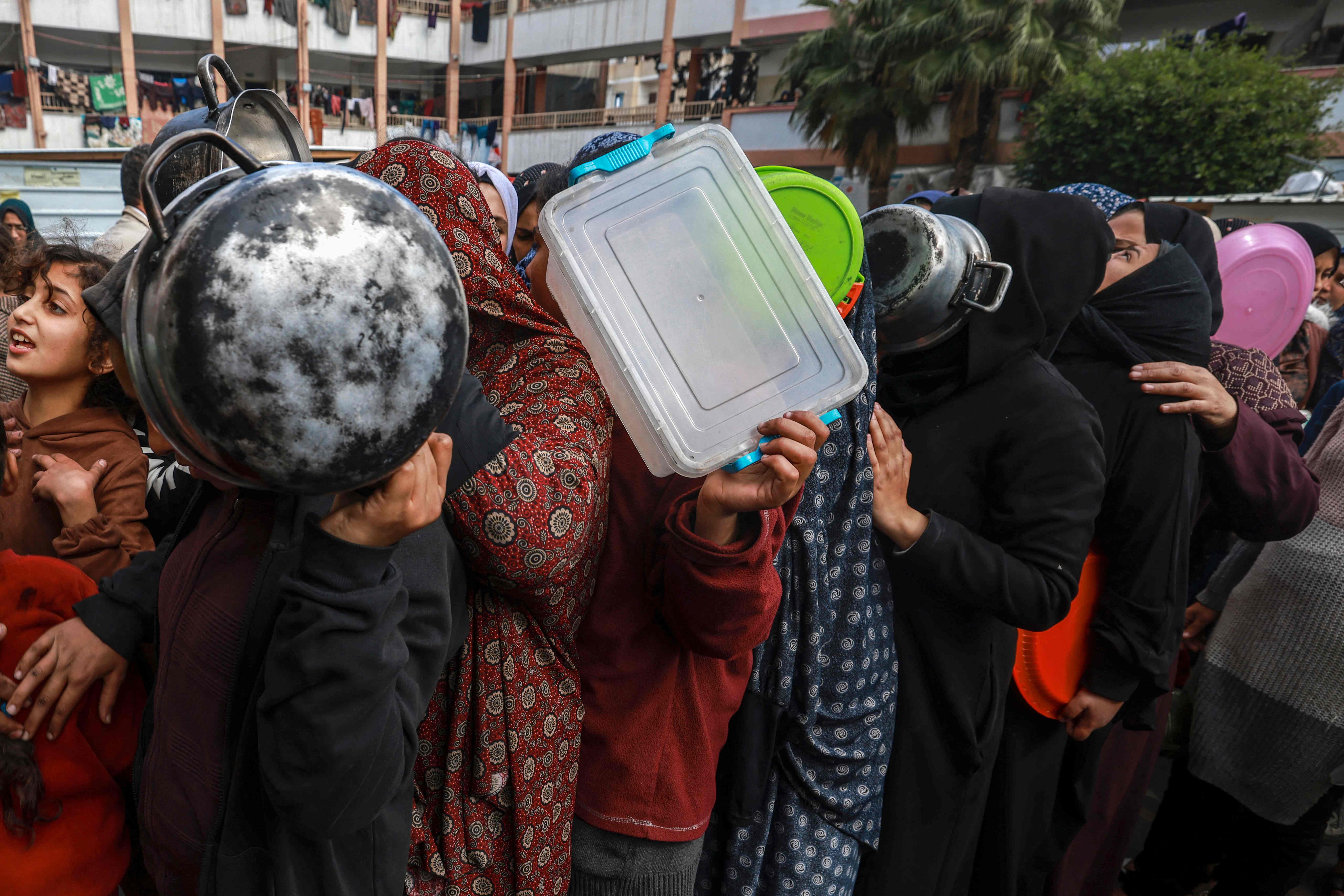 Des déplacés palestiniens attendent pour recevoir de la nourriture distribuée par une école gouvernementale à Rafah, le 19 février 2024 (Photo Mohammed ABED / AFP)