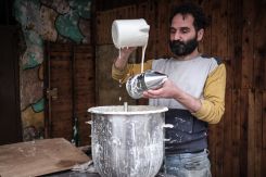 Wassim Tabboush refills the can of qatayef dough. He’ll be breaking his fast with the company of his employer. (Credit: João Sousa/L'Orient Today)