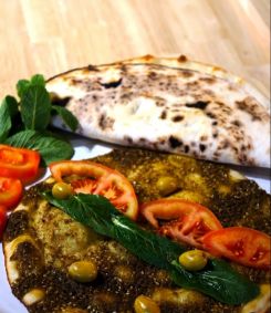 Freshly baked zaatar manaeesh served with olives, tomatoes and mint. (Courtesy of Beiruti/@beirutiofficial via Instagram)