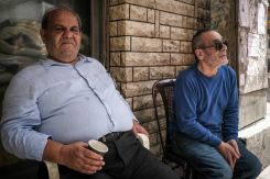 Two residents of Mar Elias, Beirut, Imad (L) and Ali Ayoub (R), sit outside Imad's laundromat and sip on tea, April 24, 2024. (Credit: João Sousa/L'Orient Today)