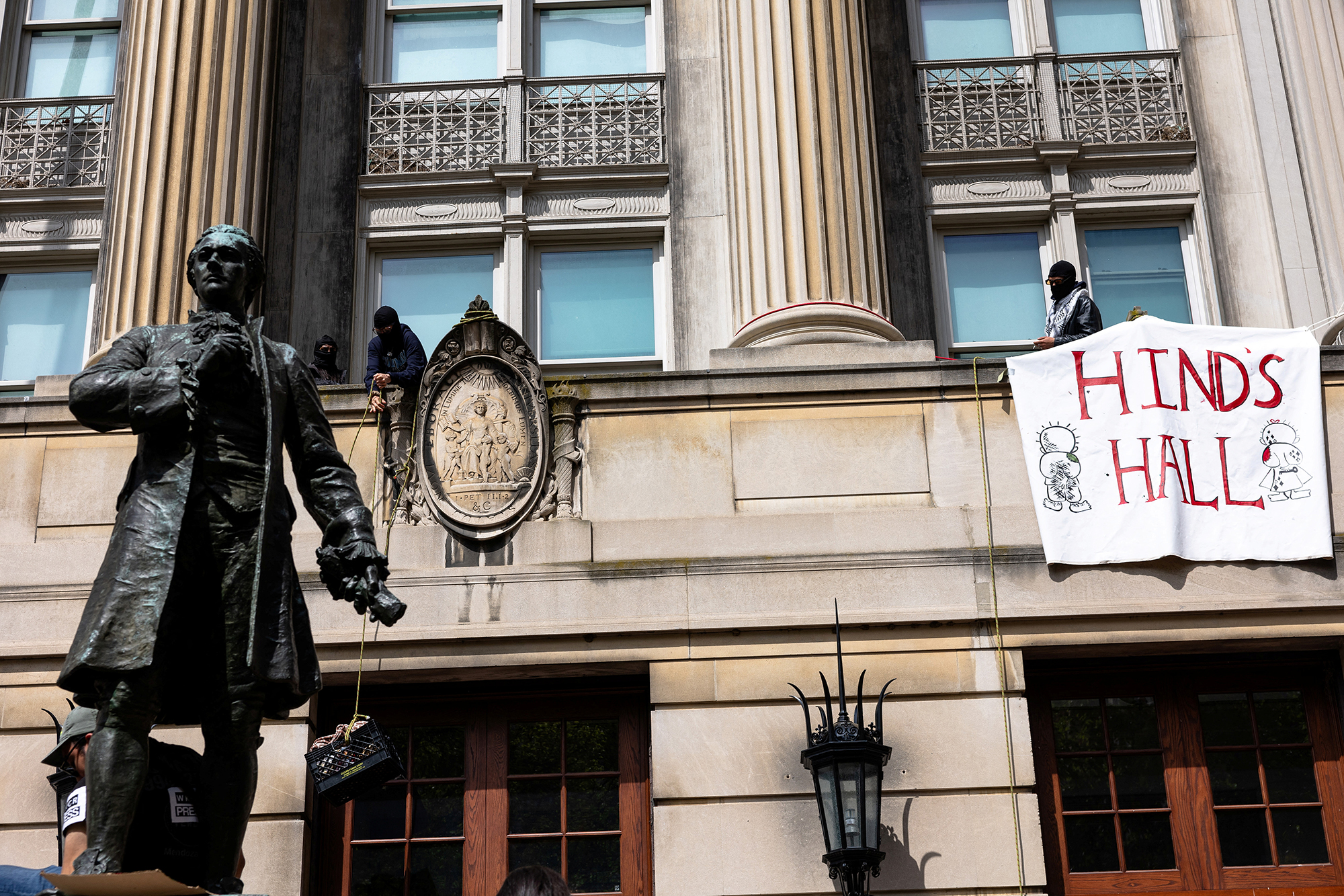 Des pro-palestiniens accrochent une banderole portant l'inscription « Hind's Hall » sur les fenêtres du Hamilton Hall de l'Université Columbia, le 30 avril à New York. Michael M. Santiago/Reuters