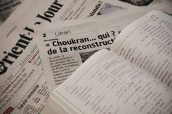 Un article de L'Orient-Le Jour du 20 avril 2024, sur lequel est posé le "Dictionnaire français libanais" des éditions Milelli. Photo d'illustration Mohammad Yassine / L'Orient-Le Jour