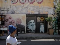 Une femme passant devant un portrait du chef du Hezbollah, Hassan Nasrallah, le 3 juin 2024, dans le quartier de Nabaa, en banlieue de Beyrouth. Photo Matthieu Karam / L'Orient-Le Jour