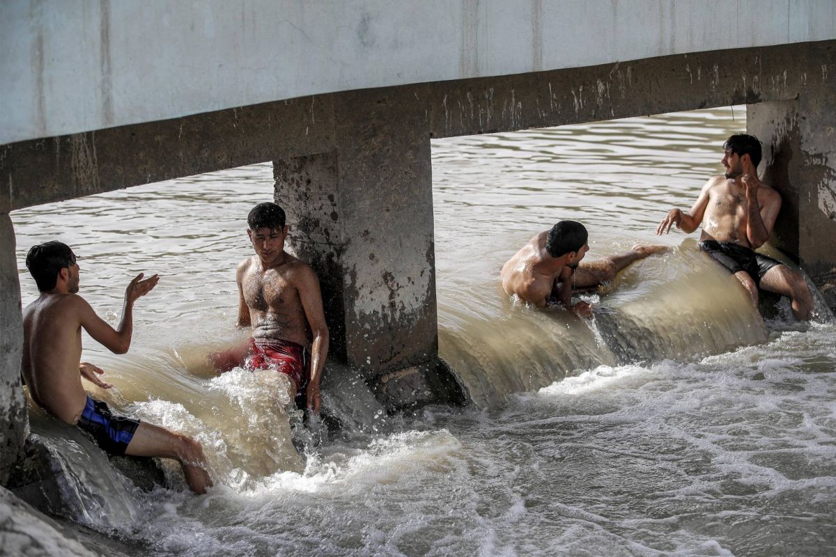 Iraqis flock to river or ice rink to escape searing heat Iraqis flock to river or ice rink to escape searing heat