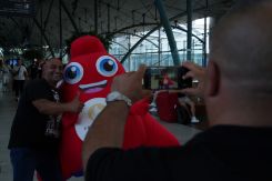 Marwan prenant Sélim en photo avec la mascotte des JO 2024, dans le hall de la gare de Lille Europe. Photo Raphaël Abdelnour/L'OLJ