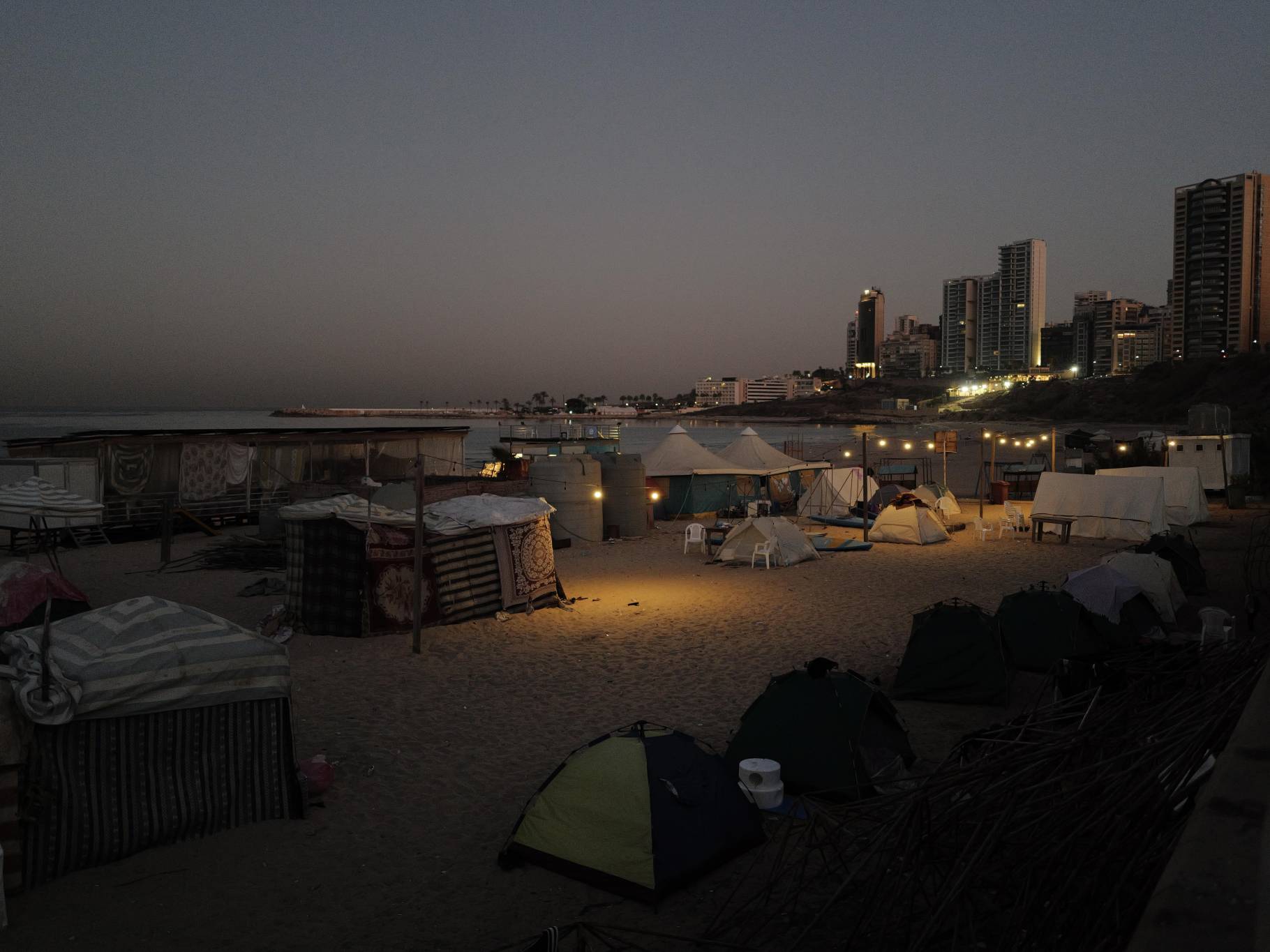 It's only a kilometer further on, on the beach of Ramlet al-Baida, that the humanitarian disaster is revealed. Here, dozens and dozens of tents have been set up on the sand, on the concrete jetty or on the sidewalks of the avenue, a little higher up. (Credit: Matthieu Karam)