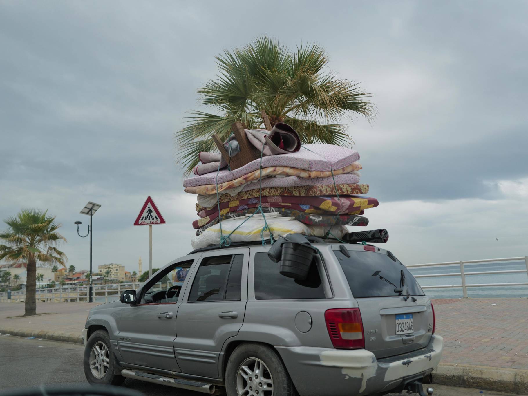 On Saida's corniche, refugees in loaded cars seem to be returning home. (Credit: Matthieu Karam)