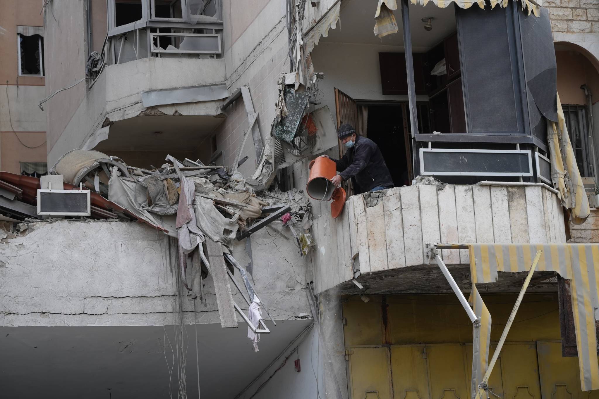 Here, another person clears debris... (Credit: Mohammad Yassine/L'Orient-Le Jour)