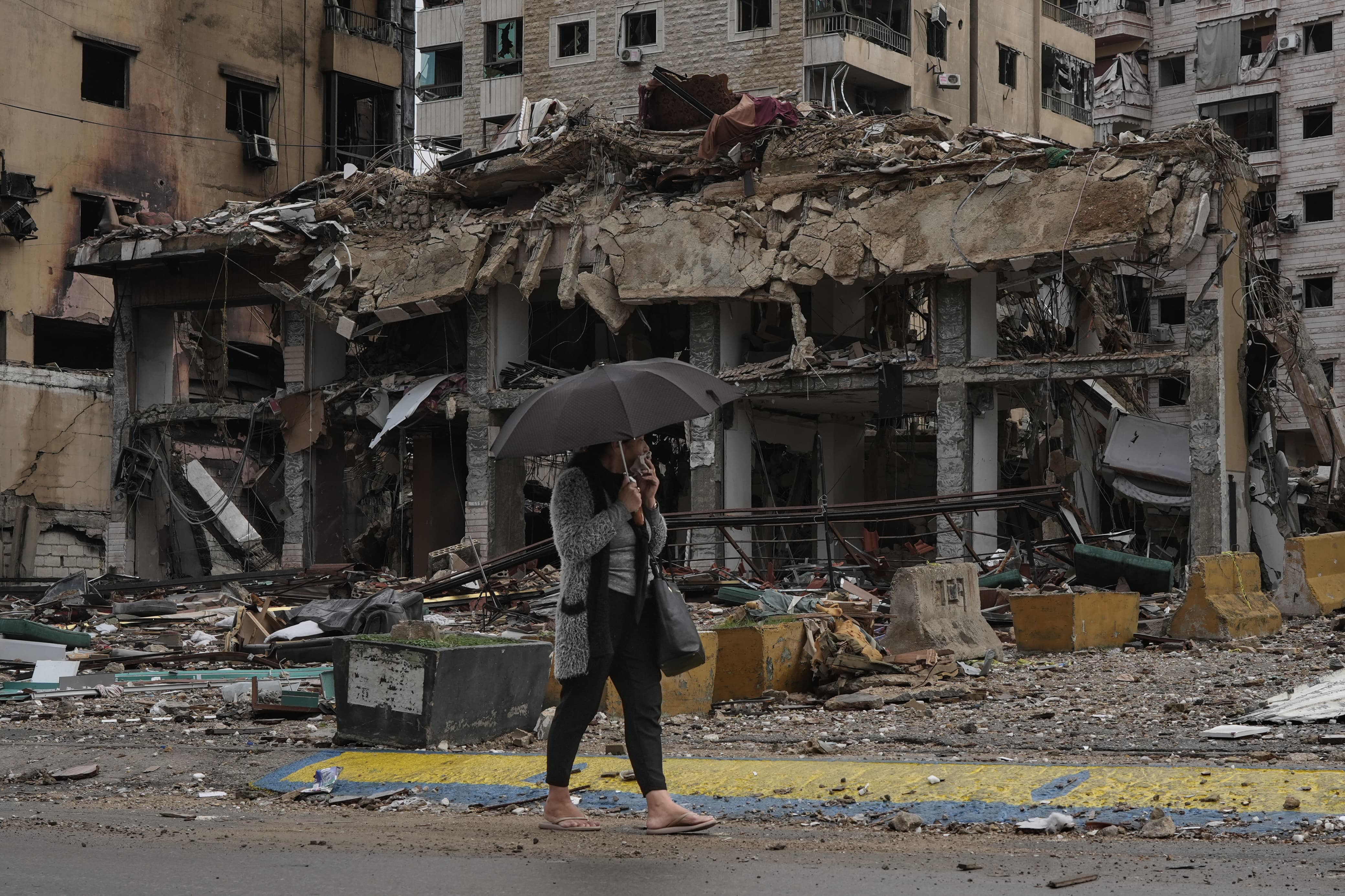 Une femme marche sous la pluie le premier jour du cessez-le-feu, dans la banlieue sud de Beyrouth, le 27 novembre 2024. Mohammad Yassine/L’Orient-Le Jour 