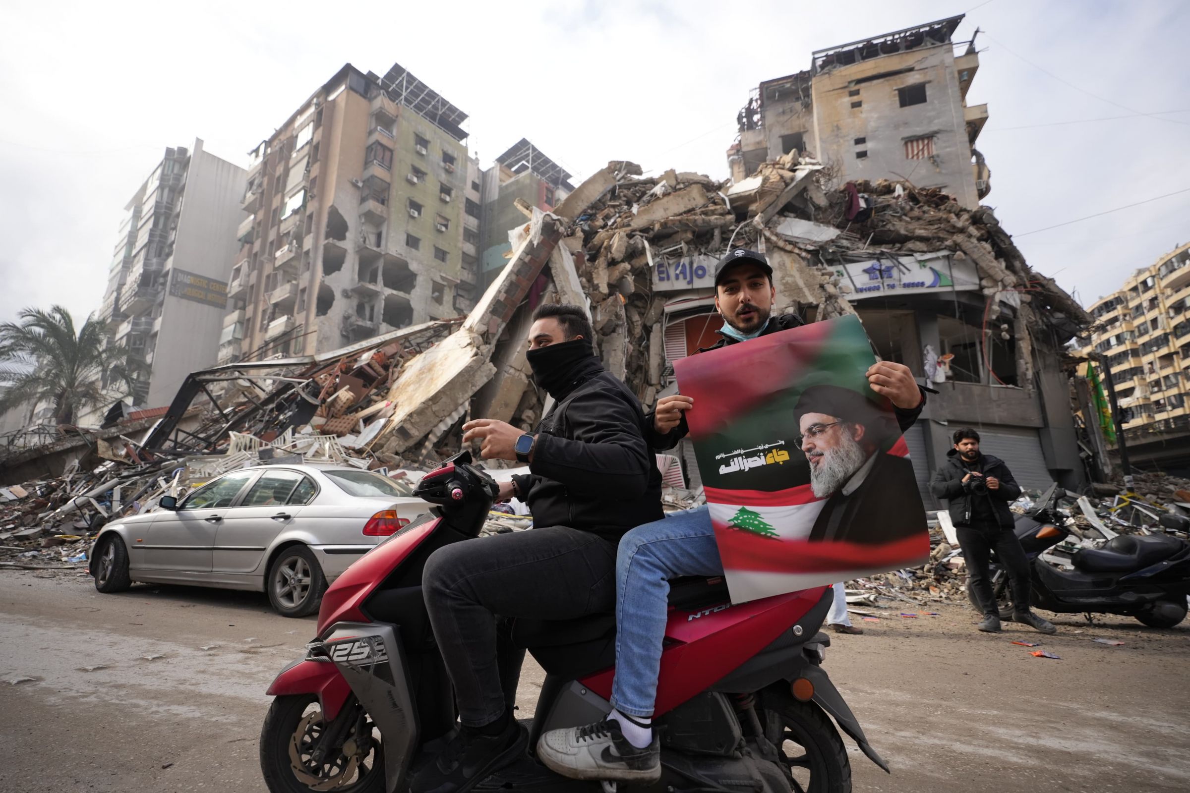 Le 27 novembre, aux premières heures du matin, des milliers de Libanais se mettent en route : direction la banlieue sud en ruines. Cela n'empêche pas les partisans du Hezbollah de parader, portraits de Hassan Nasrallah dans une main, le signe de la victoire avec l'autre. Photo Mohammad Yassine