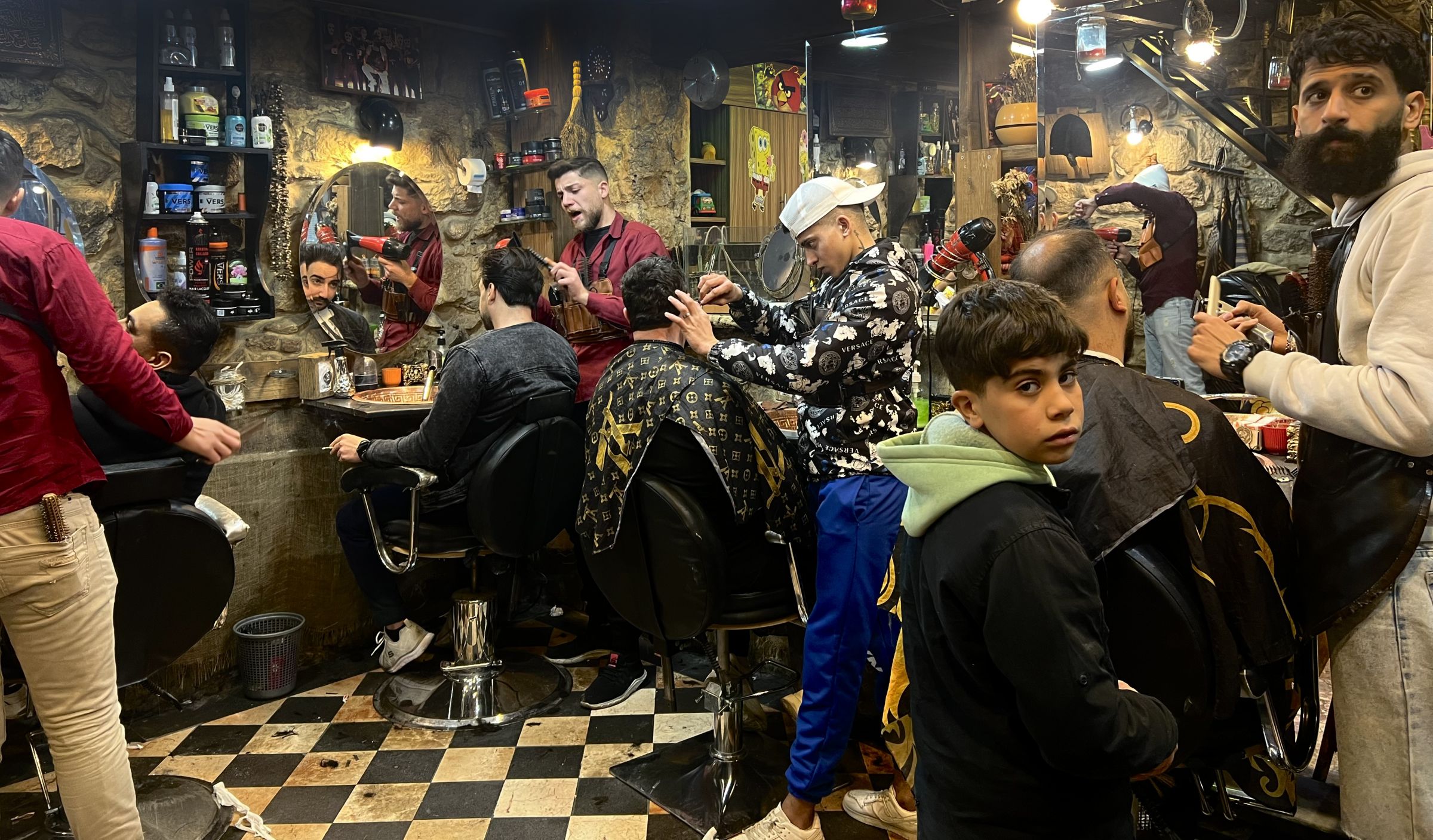 Chez un barbier de la rue al-Qomariyyé, à Damas, des hommes se préparent pour la soirée du Nouvel An, le 31 décembre 2024. Iva KOVIC-CHAHINE / L'Orient-Le Jour
