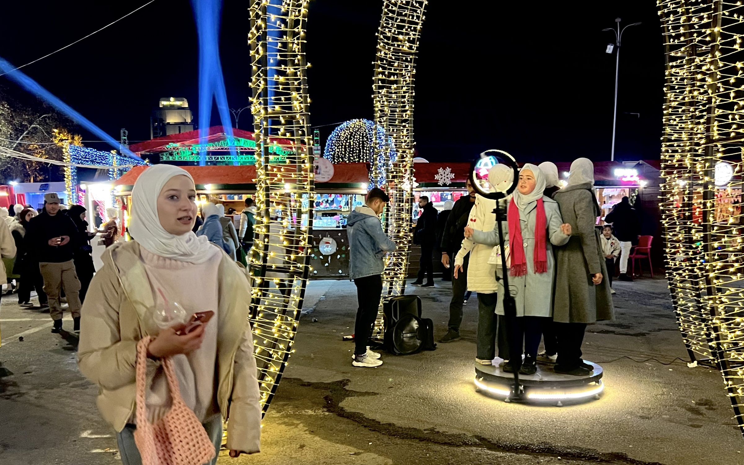 Des Syriens se promènent dans le marché de Noël, à Damas, le soir du réveillon du Nouvel An, le 31 décembre 2024. Iva KOVIC-CHAHINE / L'Orient-Le Jour
