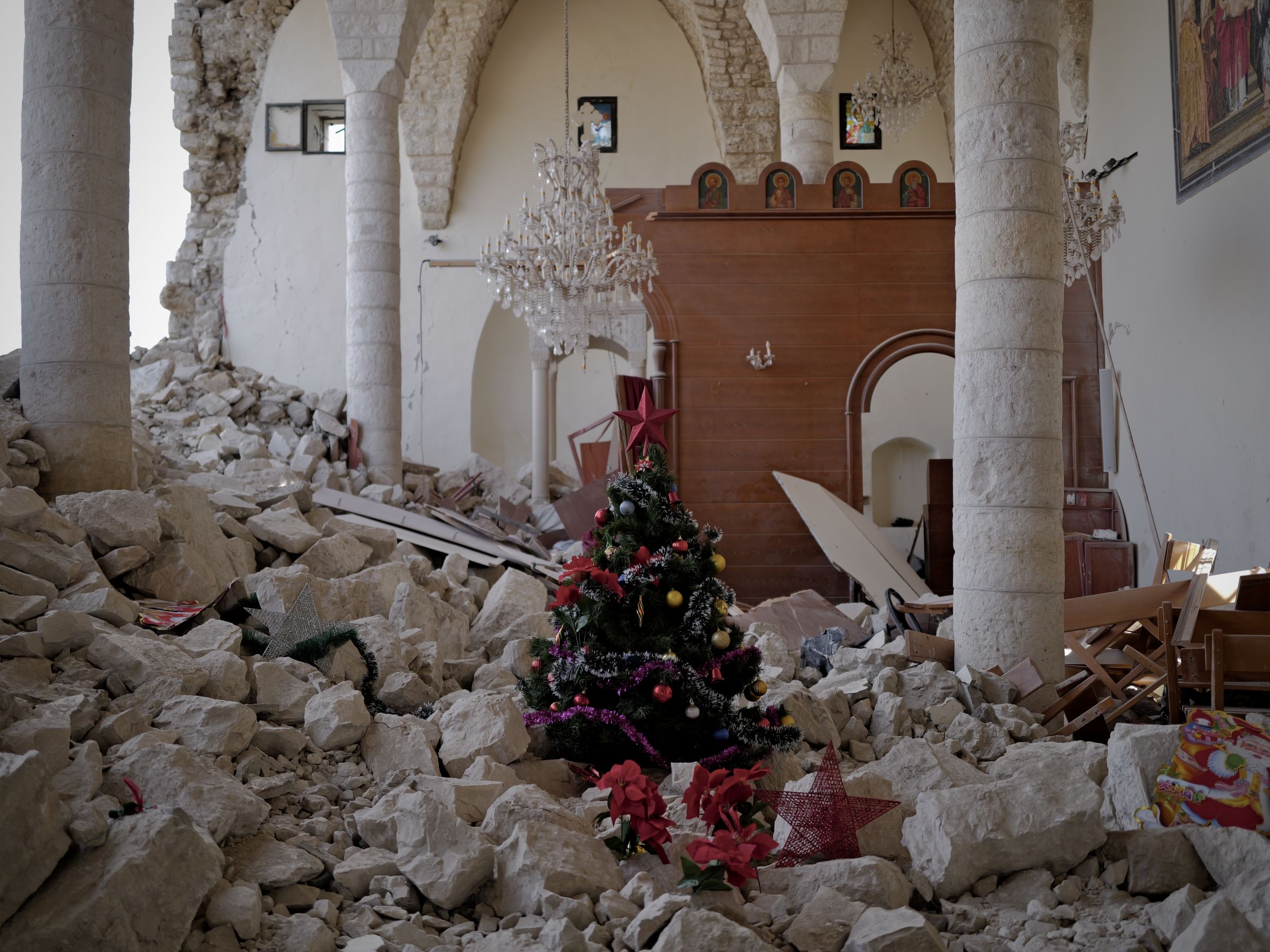 A la veille de Noël, certains tentent comme ils peuvent de célébrer les fêtes. Même s'il s'agit de le faire avec un petit sapin au milieu des ruines, comme ici, au sein de l'église Saint-Georges de Derdghaya, au Liban-Sud, le 23 décembre. Photo Matthieu Karam