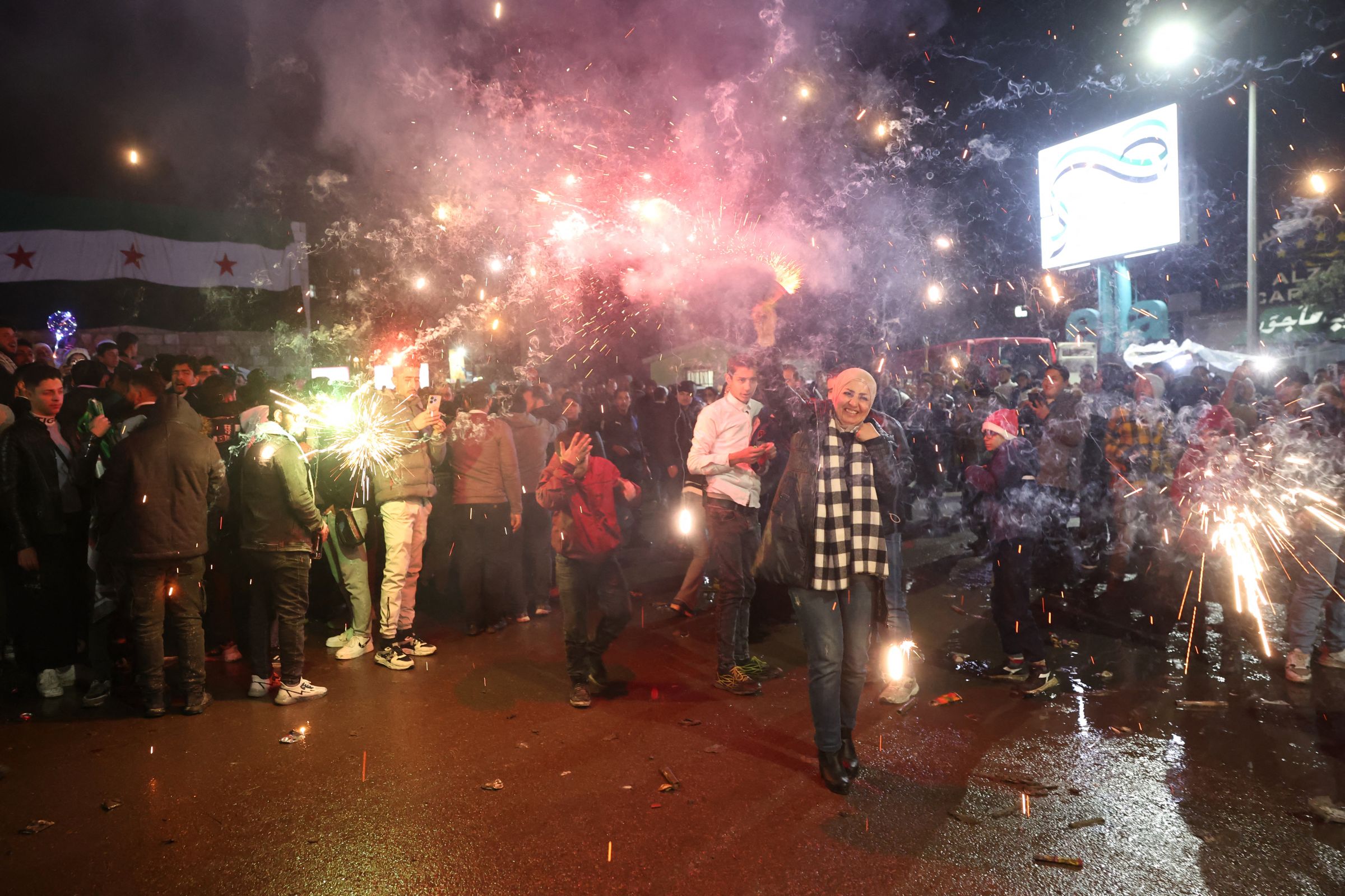 Une femme syrienne joue avec des feux d'artifice alors que les gens se rassemblent pour les célébrations du Nouvel An à Damas, le 31 décembre 2024. AFP