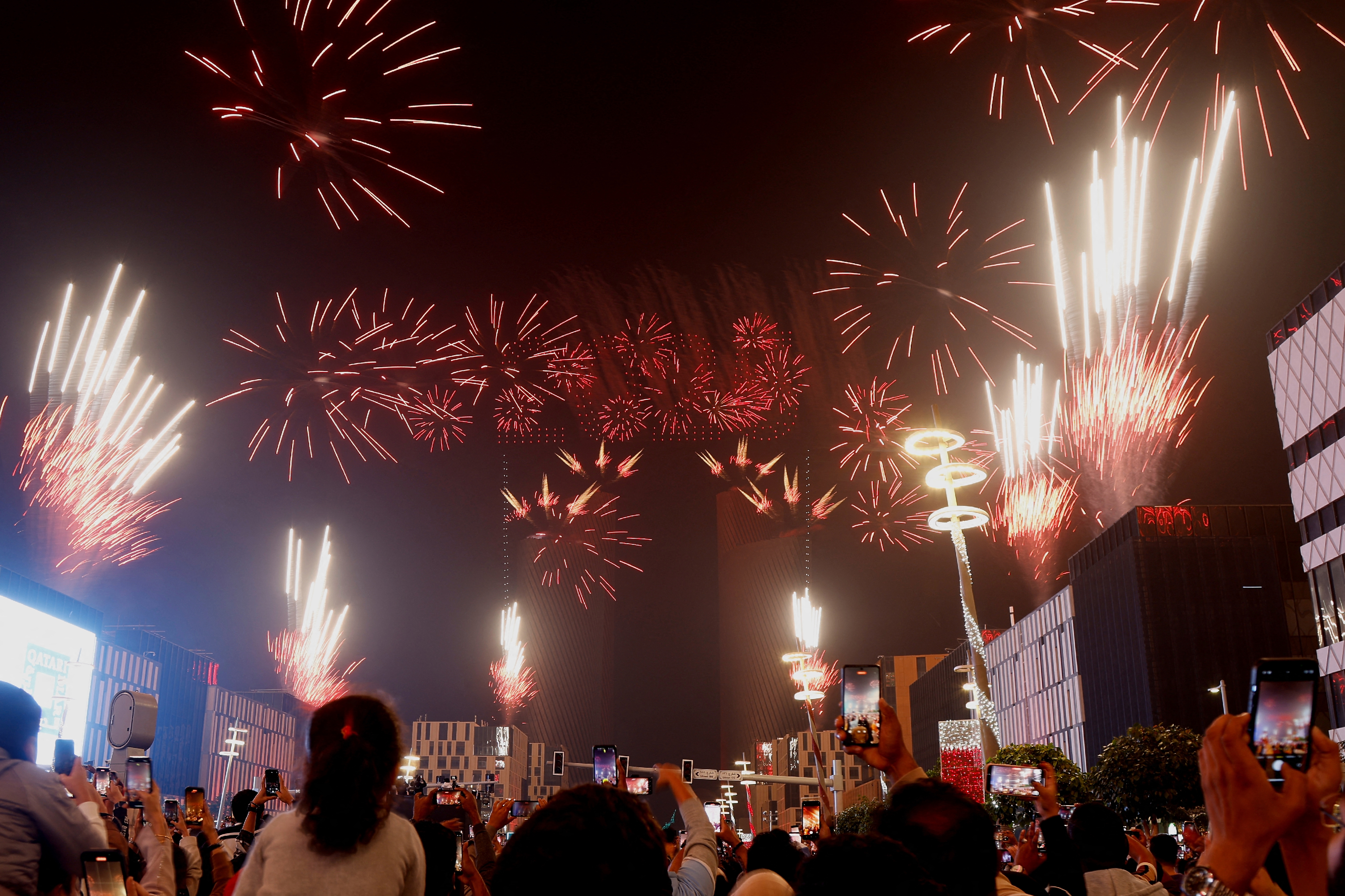 Des gens se rassemblent pour regarder un feu d'artifice et un spectacle de drones lors des célébrations du Nouvel An à Doha tôt le 1er janvier 2025. AFP