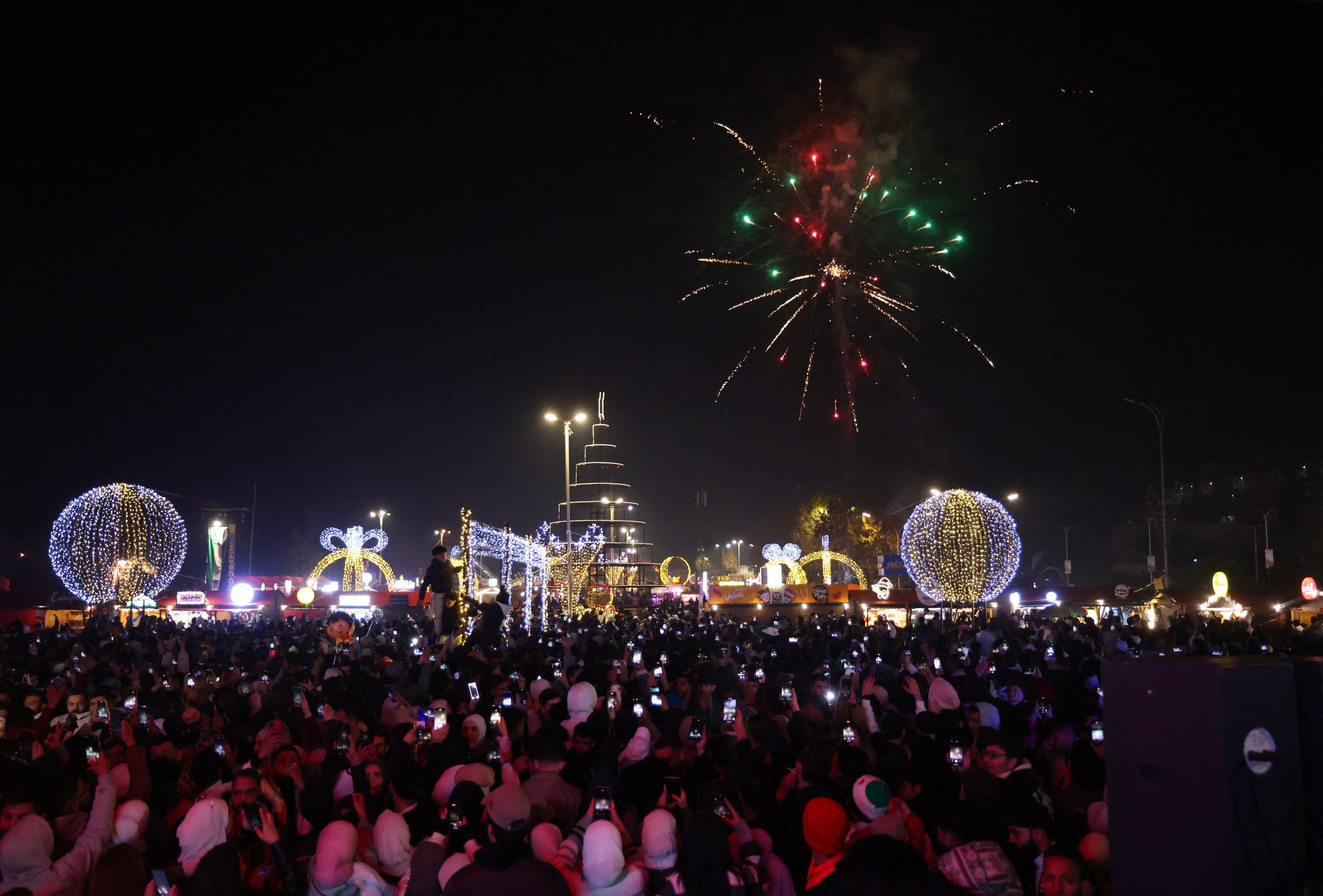 Les gens regardent des feux d'artifice alors qu'ils célèbrent le Nouvel An près de la place des Omeyyades à Damas, en Syrie, le 1er janvier 2025. AFP