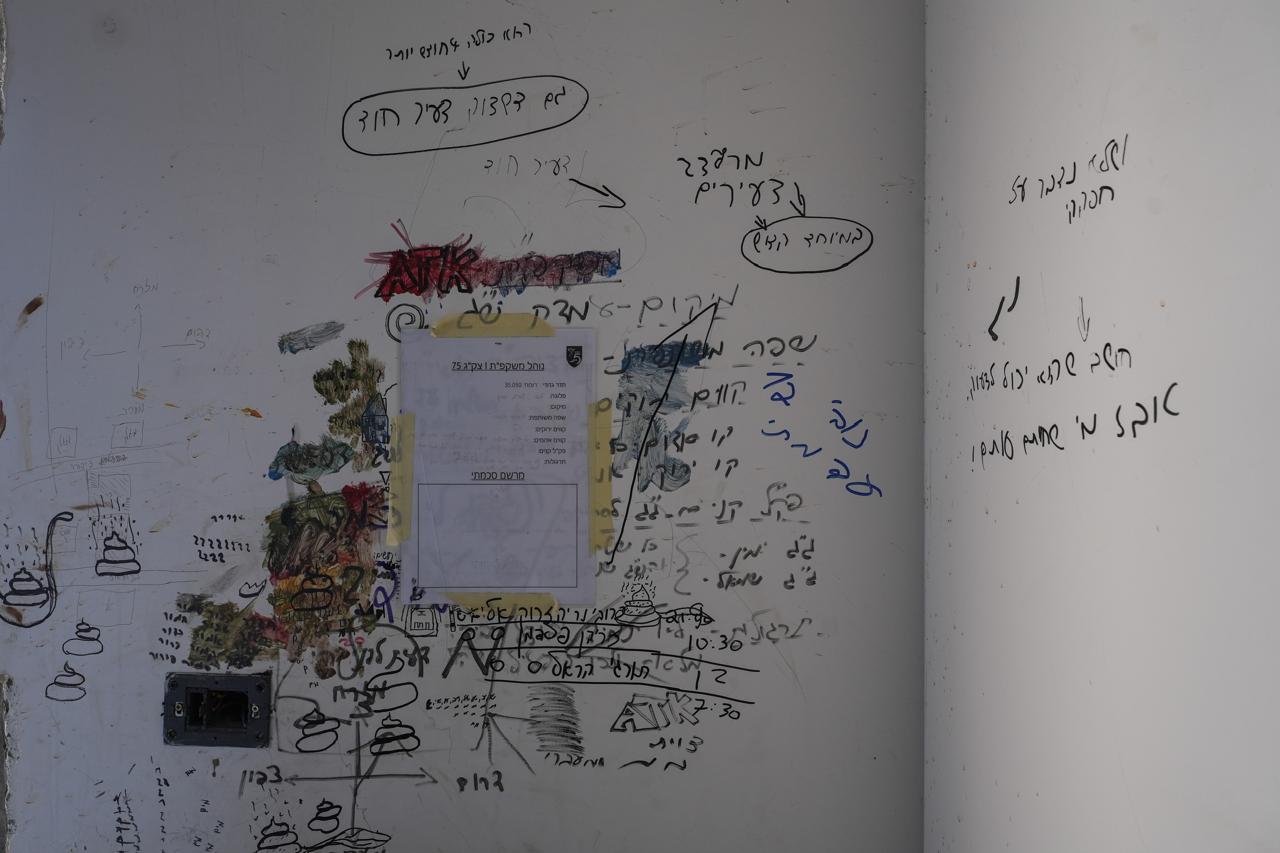 A printed military document is affixed to the wall alongside more vandalizing graffiti. It seems to outline a surveillance protocol but remains unfilled. (Credit: Mohammad Yassin/L'Orient Le-Jour)