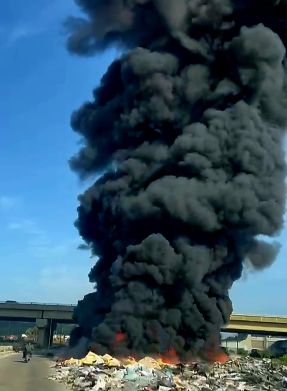 Black smoke from burning waste materials covers Tripoli's sky
