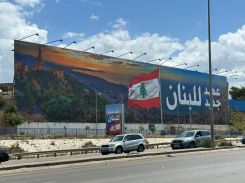 Another poster displays "a new era for Lebanon" showing the bay of Jounieh on the road to Beirut's airport, in the southern suburbs of the capital, on April 11, 2025. (Credit: Gabriel Blondel/L'Orient-Le Jour)