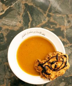 Une soupe de carottes rôties servie sur une assiette avec les mots « Les humains ont été créés à partir de boue comme de l’argile ». Image fournie par Yasmine Moufti