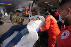 Une personne évacuée par la Croix-Rouge libanaise sous le regard d'un soldat libanais. Photo Mohammad Yassine / L'OLJ