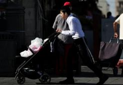A boy pushes a stroller filled with groceries as Israelis shop to prepare against retaliation by Iran. (Credit: Ronen Zvulun/Reuters)