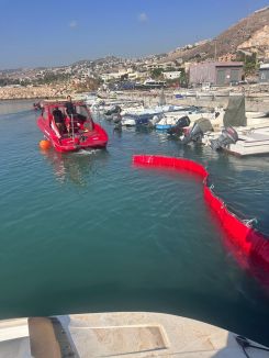 In this photo, the booms used by Civil Defense to contain the oil spill are clearly visible. (Credit: Civil Defense.)