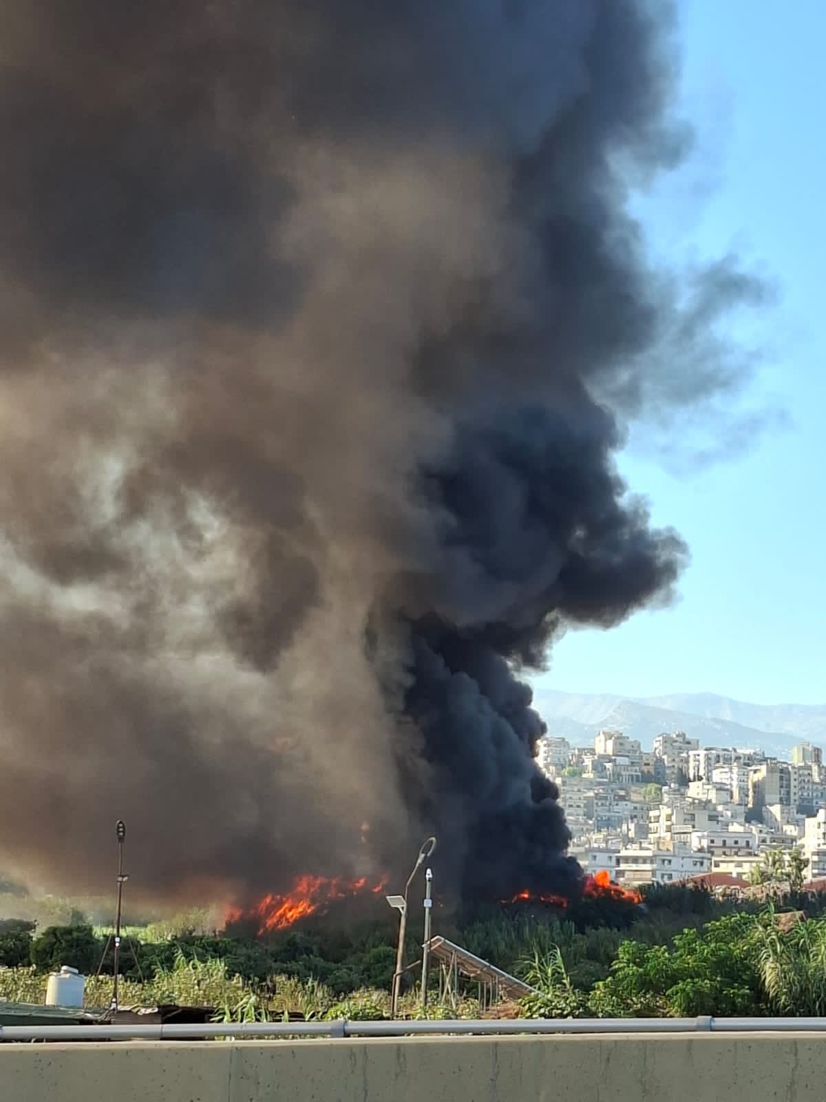 Tripoli enveloppée d'une épaisse fumée noire due à l'incinération de déchets et de pneus