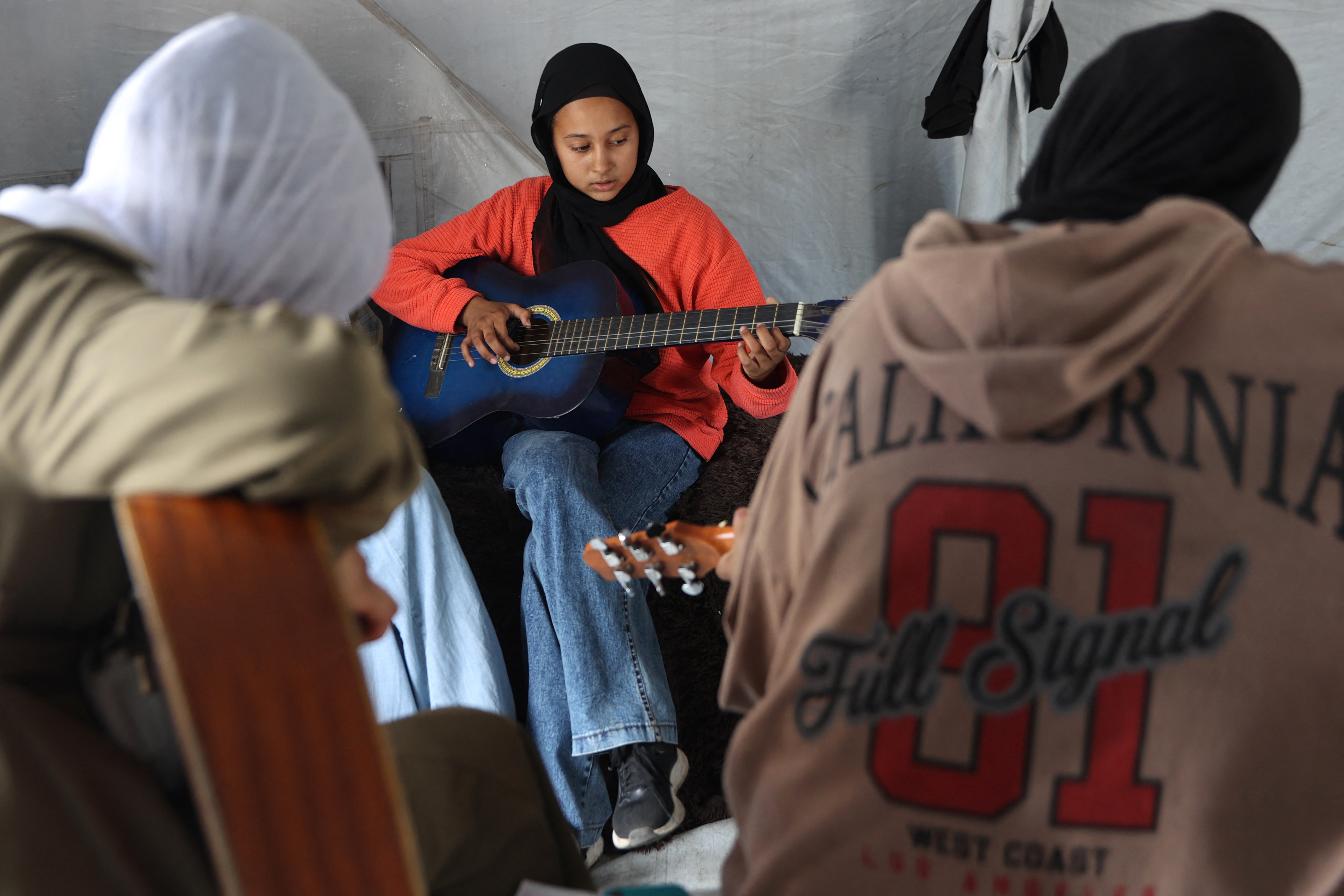 "The children of Gaza have been listening for a whole year now, surrounded by the sounds of shelling, awful sounds, cries and the voices of martyrs," Saleh Jaber, a music teacher told Reuters earlier this month. So they decided to replace the sounds of airstrikes, he explained, with the sounds of music — Palestinian music. (Credit: Omar al-Qattaa/AFP)