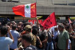 Des sympathisants rassemblées à l'AIB pour l'arrivée de Georges Abdallah, brandissant notamment un drapeau du Parti communiste libanais. Photo Mohammad Yassine/L'Orient-Le Jour
