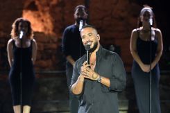 Under the spotlights, Slimane opens the evening with a knowing smile to the Lebanese audience. (Credit: Press Photo Agency.)