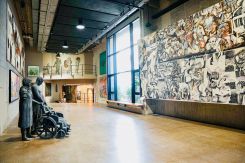 In the foreground, Mahmoud Obaidi’s sculpture “Operation Iraqi Freedom Family” faces Dia Azzawi’s tapestry “Massacre of Sabra and Shatila.” Courtesy of the Dalloul Artists Collective (DAC).