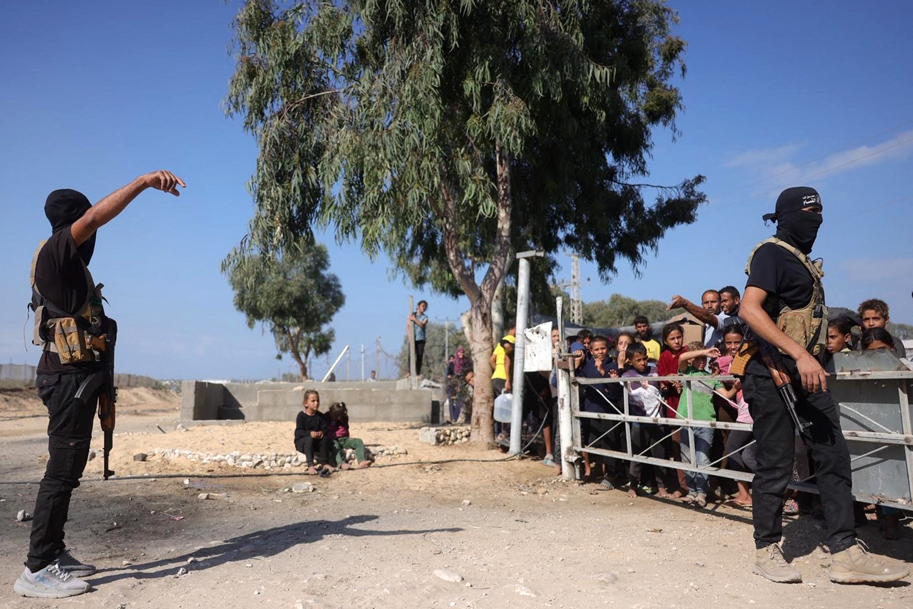 Des soldats des Brigades Ezzedine al-Qassam, la branche armée du Hamas, montent la garde avant l'arrivée des véhicules du Comité international de la Croix-Rouge (CICR) dans le sud de Deir el-Balah, dans le centre de la bande de Gaza, avant de remettre le deuxième groupe d'otages le 13 octobre 2025. Bashar Taleb / AFP