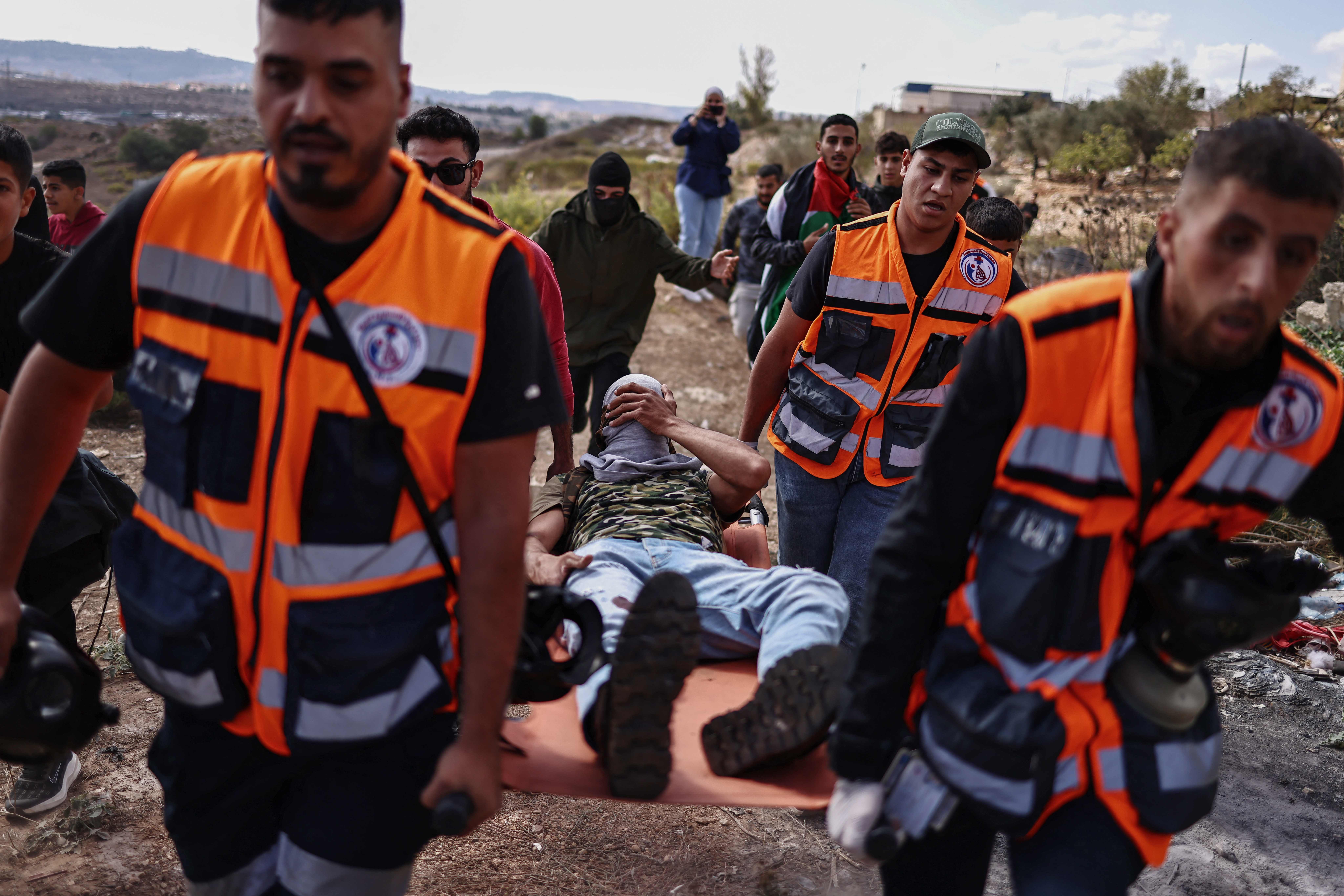 Des équipes de secours palestiniennes transportent sur une civière un manifestant blessé lors d'une confrontation avec les forces israéliennes dans la zone proche de la prison militaire d'Ofer, en Cisjordanie occupée le 13 octobre 2025, alors qu'il attendait libération de prisonniers. Zain Jaafar / AFP