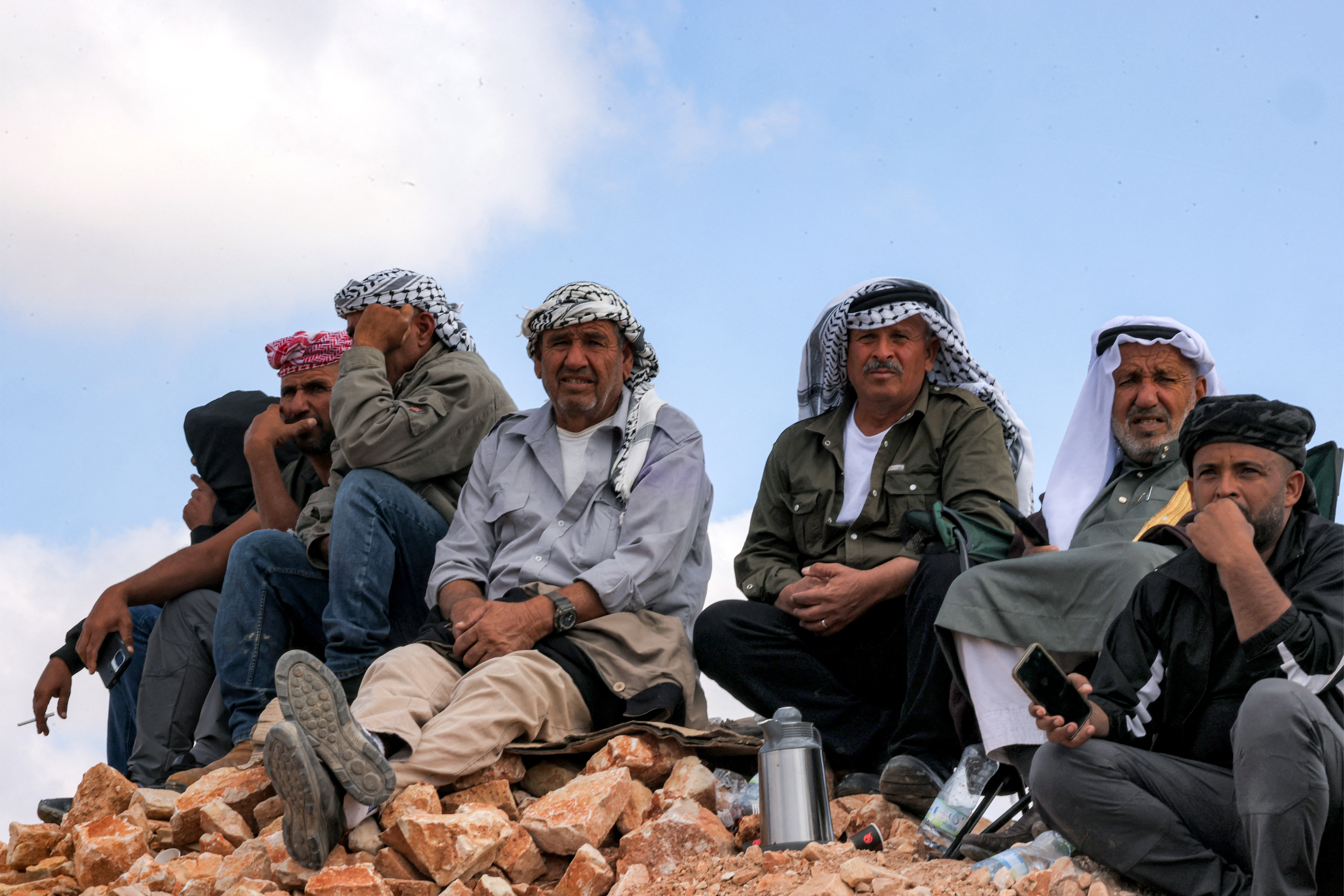 Des gens regardent, depuis une colline près de la prison militaire d'Ofer située entre Ramallah et Beitunia en Cisjordanie occupée, la libération des prisonniers palestiniens, le 13 octobre 2025. Hazem Bader / AFP