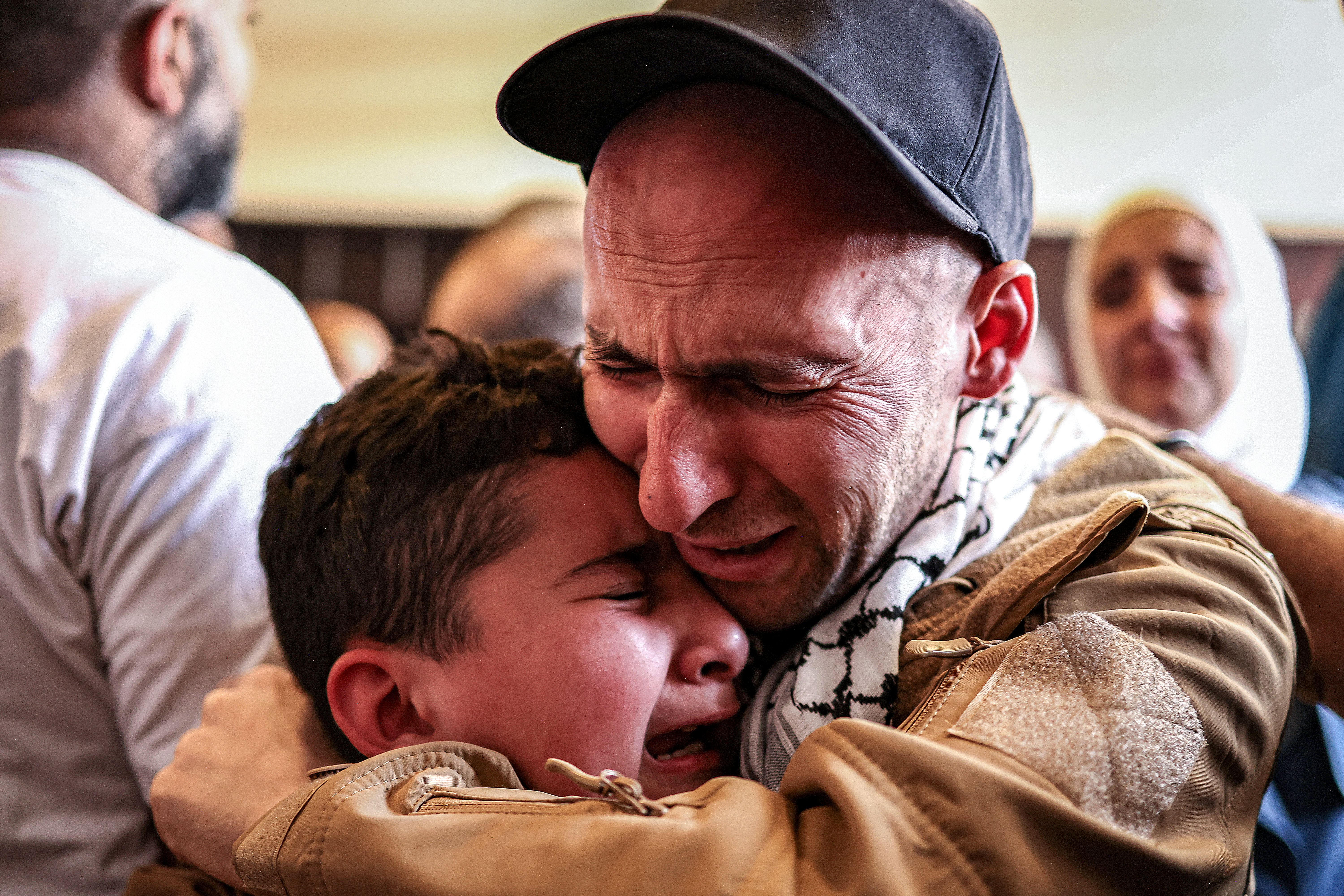 L'un des prisonniers palestiniens, libéré dans le cadre d'un échange d'otages et d'un accord de cessez-le-feu entre Israël et le Hamas, embrasse un garçon à son arrivée en bus au Centre culturel de Ramallah, en Cisjordanie occupée, le 13 octobre 2025, en provenance de la prison militaire d'Ofer dans les territoires palestiniens occupés par Israël. Zain Jaafar / AFP