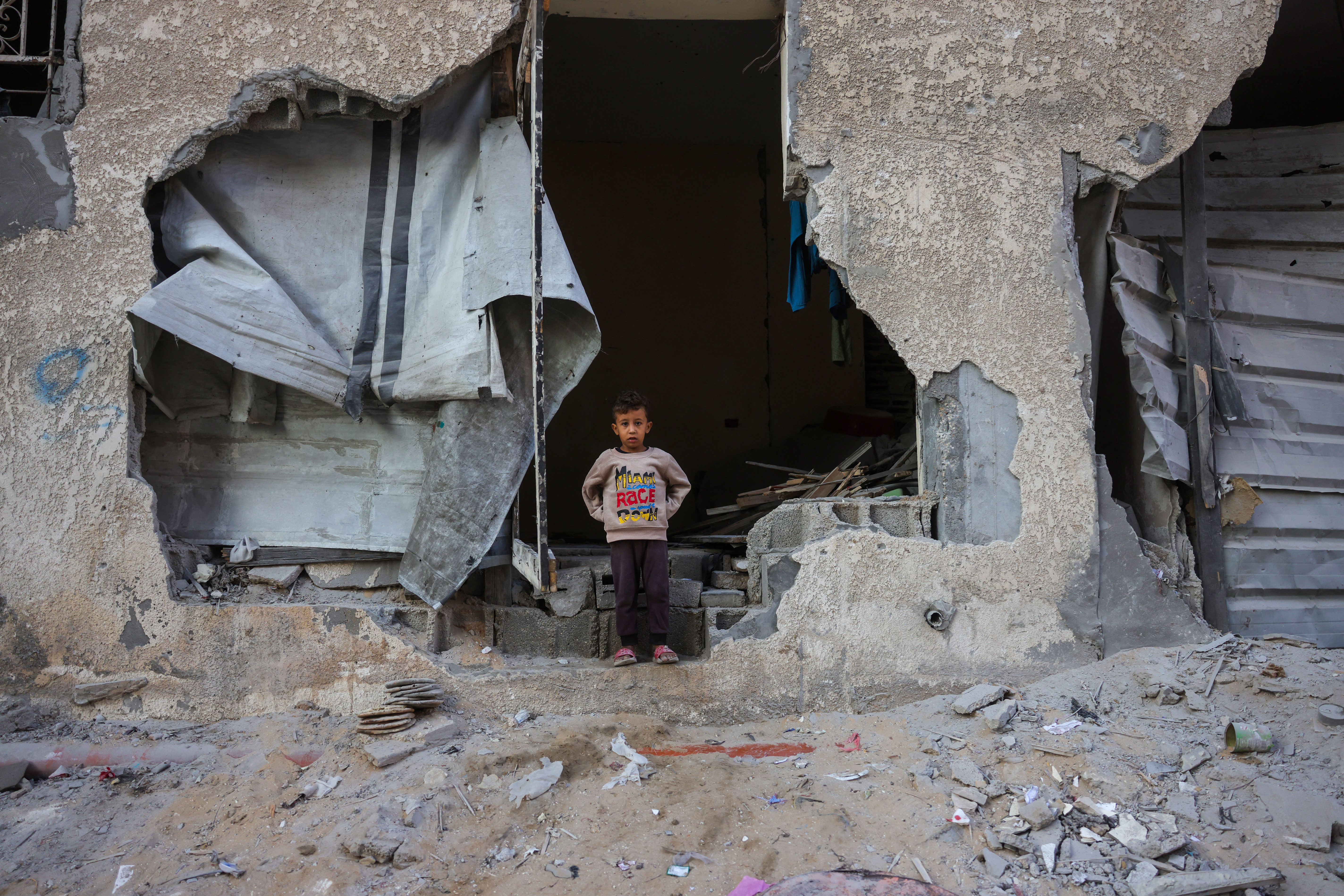 A boy stands in a wall opening of his house destroyed in an Israeli strike in Khan Younis, southern Gaza Strip, Oct. 29, 2025. (Credit: Bashar Taleb/AFP)