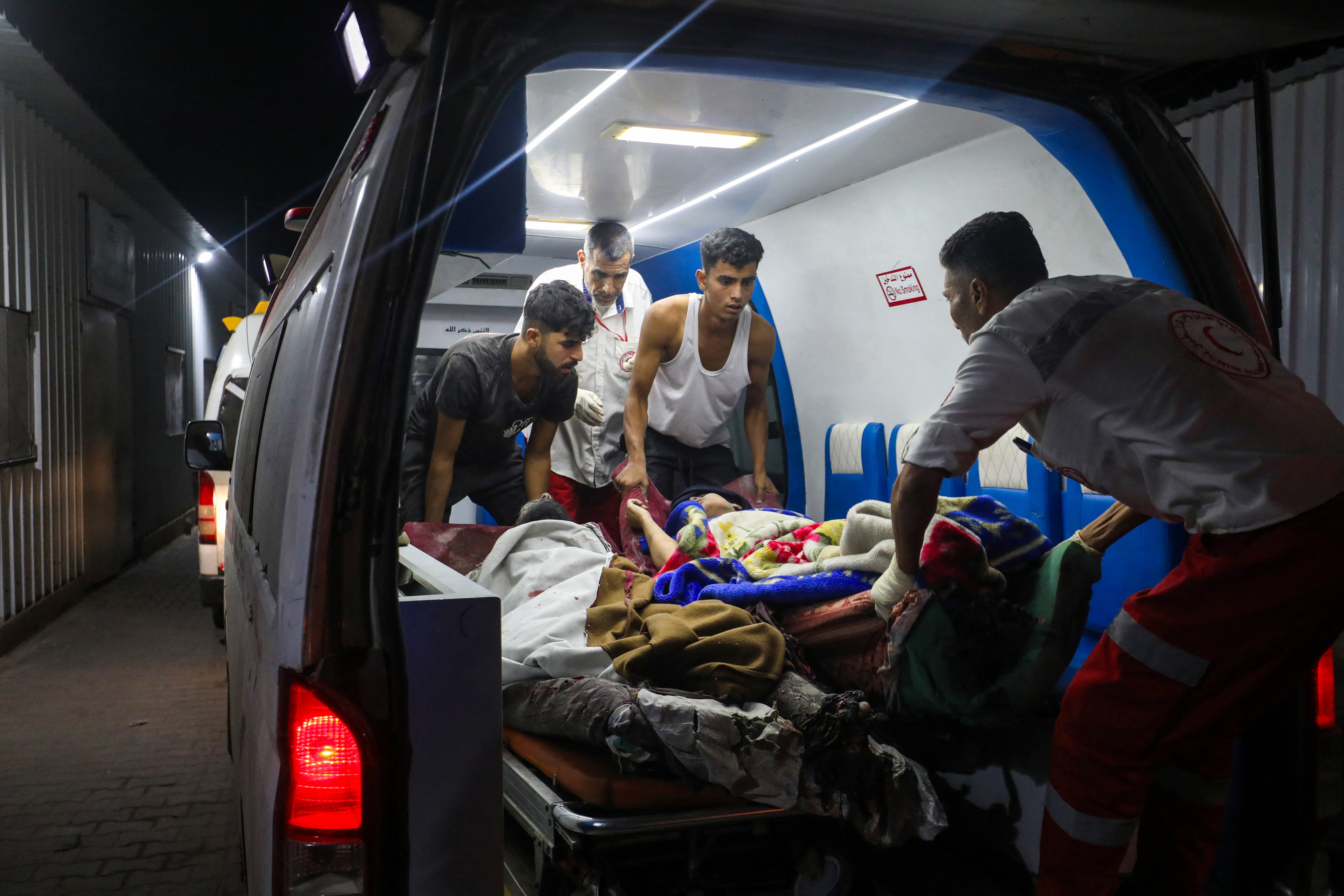 Palestinians carry a person wounded in an Israeli strike to al-Awda Hospital in Nusseirat, central Gaza Strip, Oct. 29, 2025. (Credit: AFP)