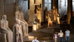Des visiteurs passent devant des statues colossales égyptiennes antiques le long du grand escalier du Grand Musée égyptien de Gizeh. Khaled Desouki/AFP