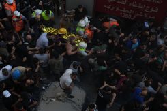 Un corps transporté par les secouristes dans la banlieue sud de Beyrouth parmi la foule. Photo Mohammad YASSINE/ L'Orient-Le Jour
