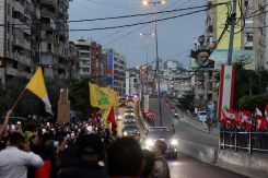 Des passants se tiennent le long d’une rue à Beyrouth, le 30 novembre 2025, jour de l’arrivée du pape Léon XIV au Liban lors de son premier voyage apostolique. Photo Khalil Ashawi/Reuters