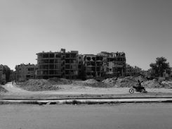 Un homme à moto devant un bâtiment endommagé par la guerre civile syrienne, le 28 mai 2025 à Harasta, en banlieue de Damas. Photo Matthieu Karam/L'Orient-Le Jour