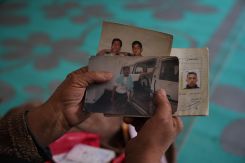 Hayat Allouche tient les photos de ses deux fils disparus dans les geôles de l’ancien régime, le 19 novembre à Otaybé, à l’est de Damas. Photo Mohammad Yassine/L’Orient-Le Jour