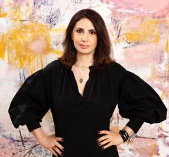 Noha Mouharram posant dans sa galerie Art on 56th devant une toile de Sara Chaer. Photo fournie par la galeriste