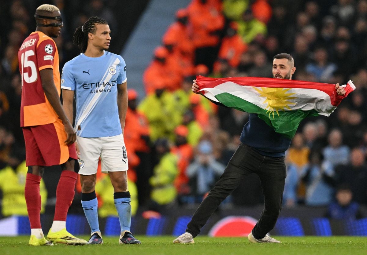 Kurds storm pitch at Manchester stadium during match against Turkish club