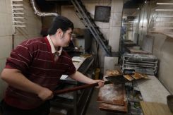 Un employé de la boulangerie d'Élie Jaber prépare des mana'ich, le 3 mars 2026. Photo Renée Robledo-Davis/L'Orient-Le Jour