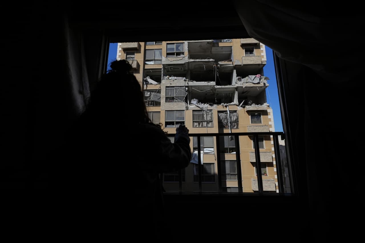 Une fillette observe, de son balcon, les dégâts causés par la frappe sur l'immeuble, juste en face de chez elle. « J’ai pris mes gamins sans réfléchir et j’ai couru, après avoir entendu deux ou trois frappes », a dit, à notre reporter, le père de trois enfants âgés de 1,4 et 8 ans, vivant dans l’immeuble. « Nous sommes sous le choc », a-t-il poursuivi. Photo Mohammad Yassine / L'Orient-Le Jour